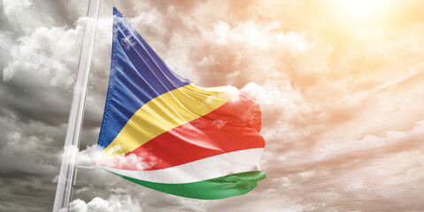 Seychelles national flag cloth fabric waving on beautiful cloudy Background.