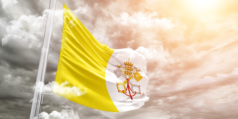 Vatican City national flag cloth fabric waving on beautiful cloudy Background.