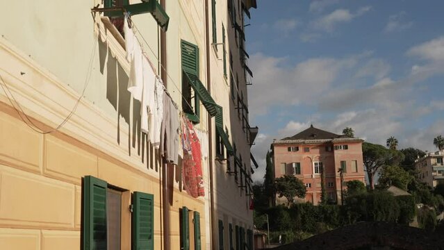 clothes hanging from a building in the sun on a summer day
