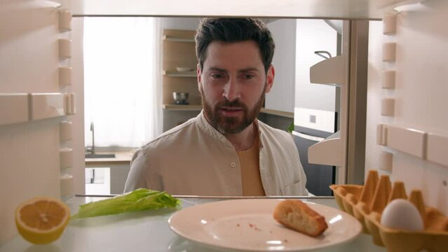 POV empty refrigerator point of view from inside fridge with one egg lettuce half lemon slice bread Caucasian middle-aged man adult male guy confused sniffing bad smell odor stench stink spoiled food