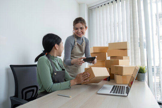 Online salespeople are selling products through online platforms and packing them into parcel boxes to prepare for delivery.