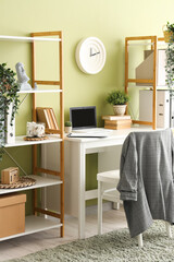 Interior of stylish office with workplace, shelf units and plants