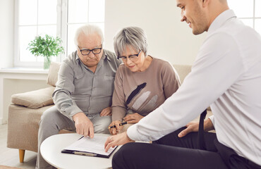 Obraz premium Senior pair and young consultant providing care, giving expert advice, signing documents help. Elder care consulting service, geriatric management for older people, financial counseling, social work