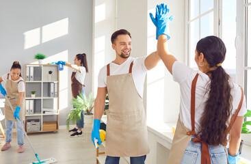 Team of service cleaning staff, home and office cleaners, giving high five with smile. Unity and teamwork during housecleaning, exchanging high five, positive spirit of collective work. - 772119075