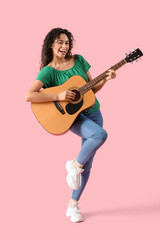 Fototapeta na wymiar Young African-American woman playing acoustic guitar on pink background