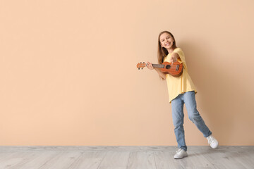 Teenage girl with ukulele pointing at viewer on beige background