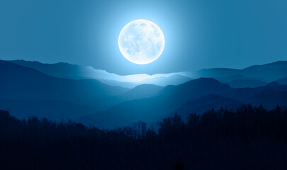 Beautiful landscape with blue misty silhouettes of mountains against super blue moon "Elements of this image furnished by NASA"