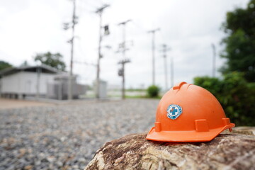 Orange safety helmet on the stone in the construction site power distribution station, stock photo - 772131686