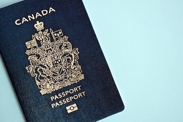 Canadian passport on blue background close up. Tourism and citizenship concept