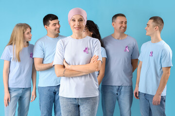 Mature woman after chemotherapy and people with lavender awareness ribbons on blue background....