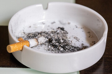 Cigarrillo sobre cenicero a punto de consumirse