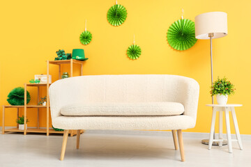 Interior of festive living room with white sofa and decorations for St. Patrick's Day celebration