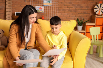 Female psychologist showing pictures to little boy in office