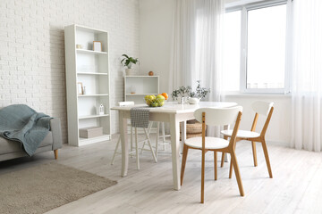 Interior of light room with dining table and shelf units