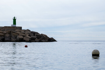Two balls in the sea next to the lighthouse - obrazy, fototapety, plakaty