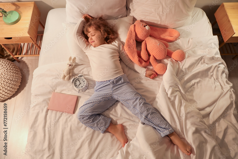 Canvas Prints adorable little girl with plush toys, book and alarm clock sleeping in bed