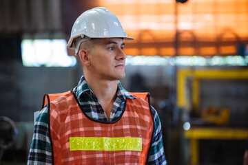 Portrait of male foreman factory wearing hardhat looking at camera standing at the industry...
