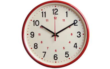 A red and white clock contrasts against a white wall, marking the passage of time