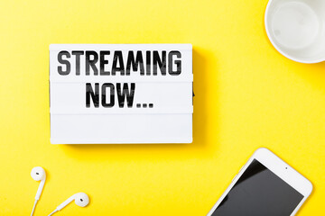 Streaming Now headline in notebook with electronic devces on yellow background