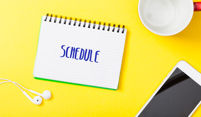 Schedule word in notebook on bright flat lay background