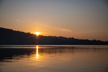 Views of the sunrise at Lake Beratan with boats on shore, Bali