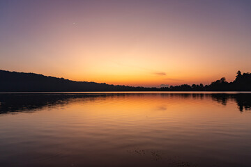 Obraz premium Views of the sunrise at Lake Beratan with boats on shore, Bali