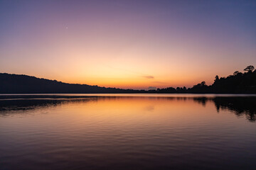 Views of the sunrise at Lake Beratan with boats on shore, Bali