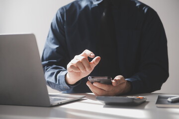 Side view shot of a man's hands using smart phone in interior, rear view of business man hands busy using cell phone at office desk, young male student typing on phone sitting at wooden table, flare