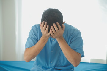 A male patient suffering from stress, migraines, eye strain, headaches, eye problems from working hard and not getting enough rest receives treatment from a doctor at the hospital.