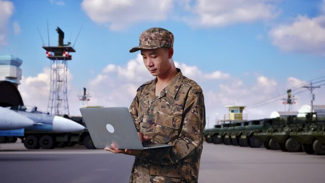 Side View Of Asian Man Soldier Using A Laptop While Standing At Military Camp