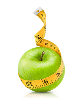 sewing measuring tape wrapped around a green apple on an isolated white background. diet and weight loss concept