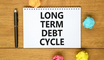 Long term debt cycle symbol. Concept words Long term debt cycle on beautiful white note. Beautiful wooden table background. Colored paper. Black pen. Business Long term debt cycle concept. Copy space.