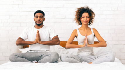 Couple engaging in a meditative practice on bed