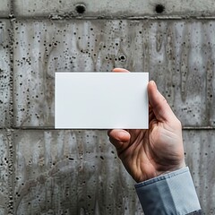 A man holds a white business card against the background of a concrete wall. generative ai