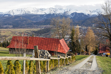 ZAKOPANE, POLAND - MARCH 29, 2024: Rural road through the fields leading to Zakopane, Poland.