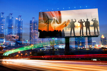 the advertising of businessman and silhouette of business team with wind turbine farm at sunset on billboard with city night background	
