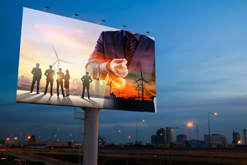 the advertising of businessman and silhouette of business team with wind turbine farm at sunset on billboard with city night background		