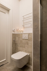 Wood flooring and fixtures in bathroom with toilet and shower stall