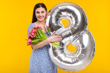 Happy Women's Day. Charming lady holding bouquet of beautiful flowers and balloon in shape of...