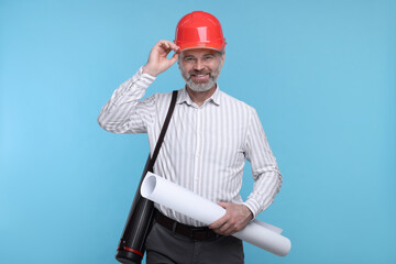 Architect in hard hat holding draft on light blue background