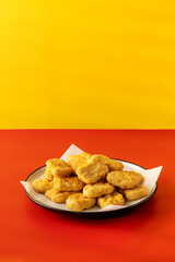 Delicious golden chicken nuggets on a plate on the table. Fast food, menu.