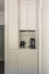 White cabinetry, coffee maker, and kettle in a kitchen