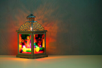 Decorative Arabic lantern on table against dark background. Space for text