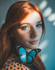 ritratto bella donna ragazza rossa con lentiggini farfalla blu 