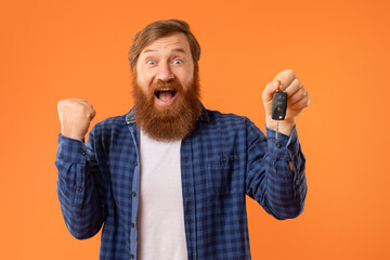 Emotional Bearded Redhaired Man Showing Automobile Key Gesturing Yes, Studio