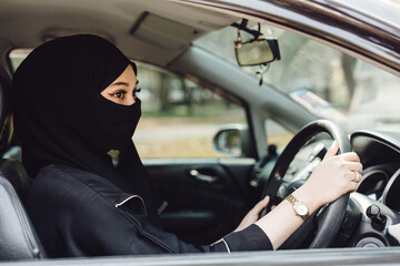 Saudi muslim women driving a car. Modern arab lady drive automotive vehicle.