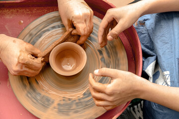 Master class on clay modeling on a potter's wheel. Tutor teaching a child