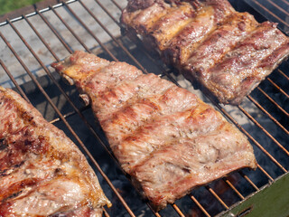 Roasted Juicy spare ribs cooked over the coals on a barbecue. Summer and holiday time. Delicious food