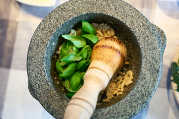 Preparation of traditional Pesto alle Genovese - with basil, olive oil, pine nuts, parmesan cheese...