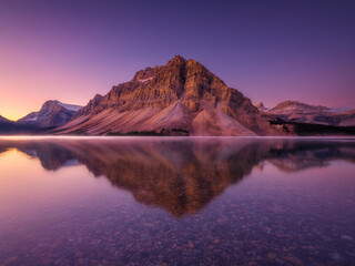 Bow lake, Alberta, Canada. Mountain landscape at dawn. Sunbeams in a valley.